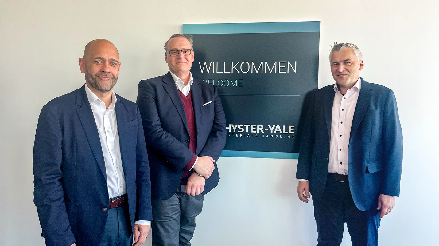 Hyster-Yale leaders standing in front of ‘welcome’ sign at the new German facility.