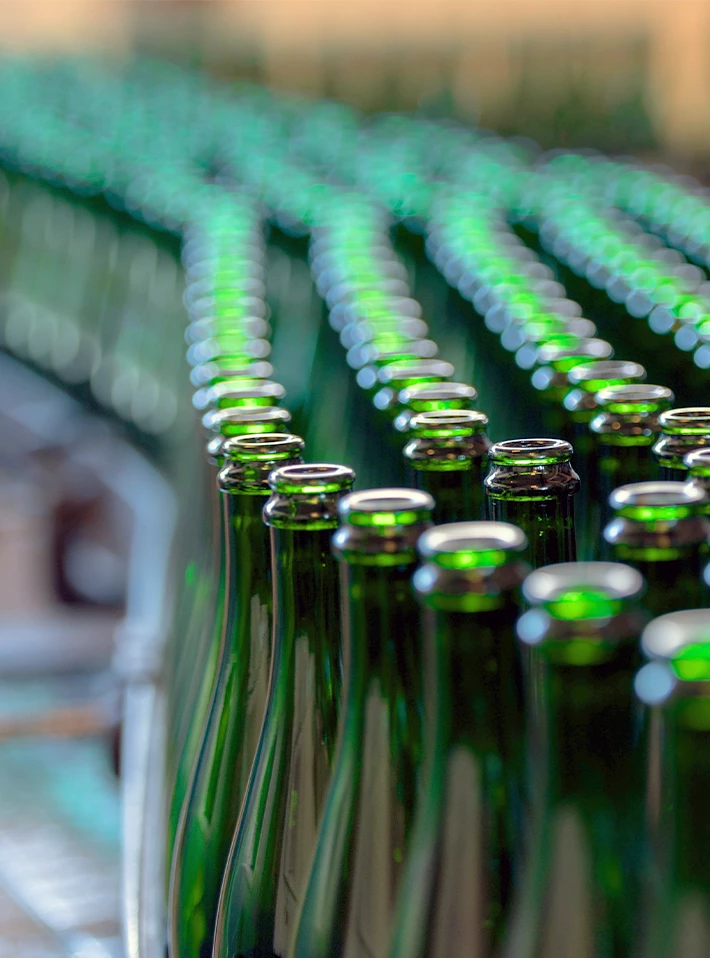 Green bottles on conveyer in beverage bottling plant. 