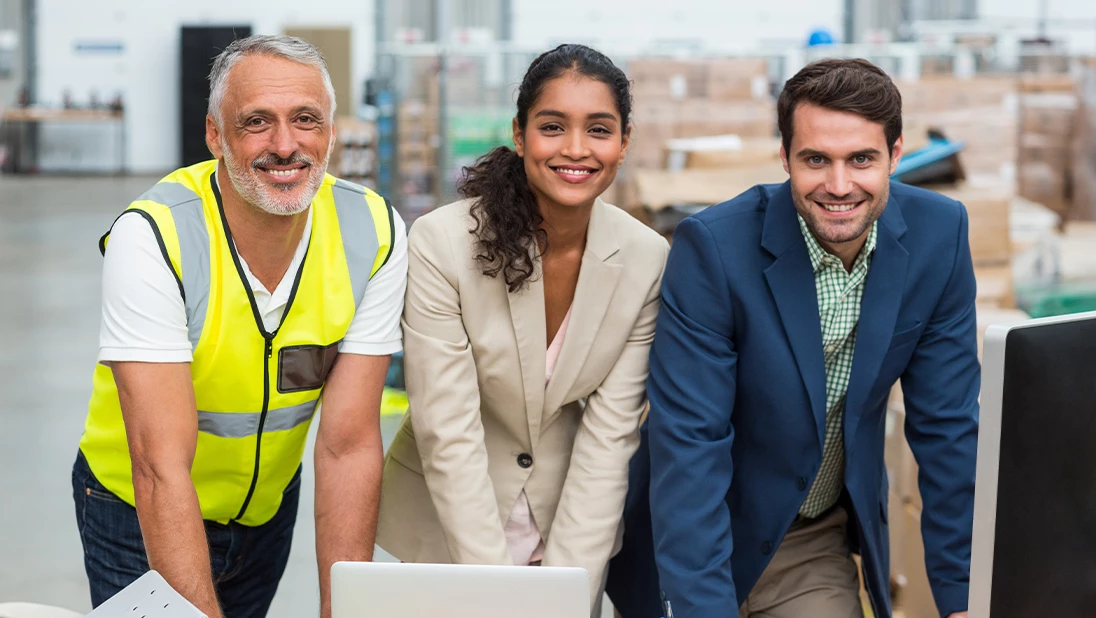Group of people smiling in a warehouse. 