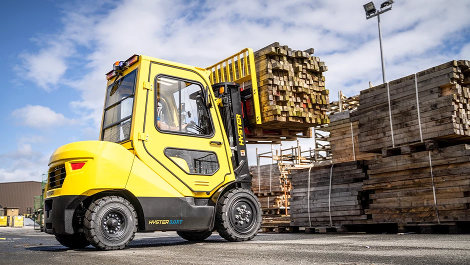 Hyster XT truck transporting load of lumber.