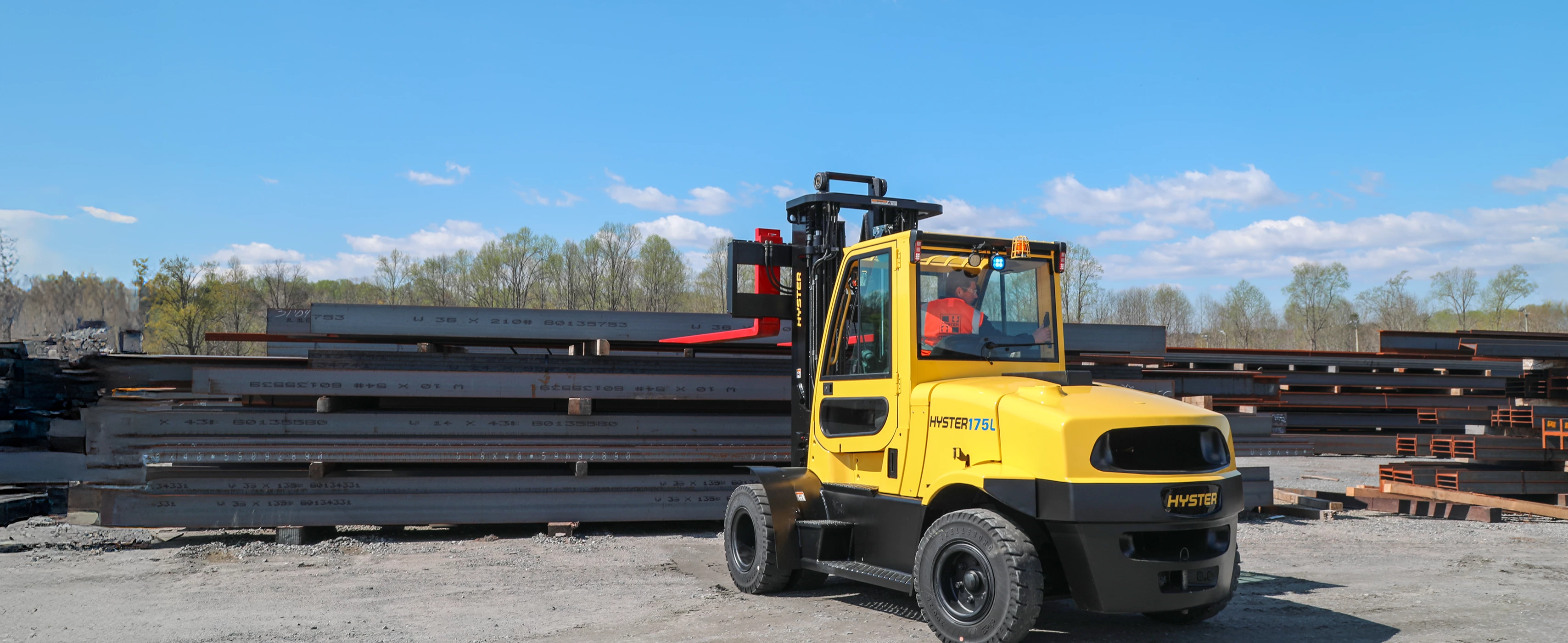 Hyster high-capacity electric forklift approaching steel beams.