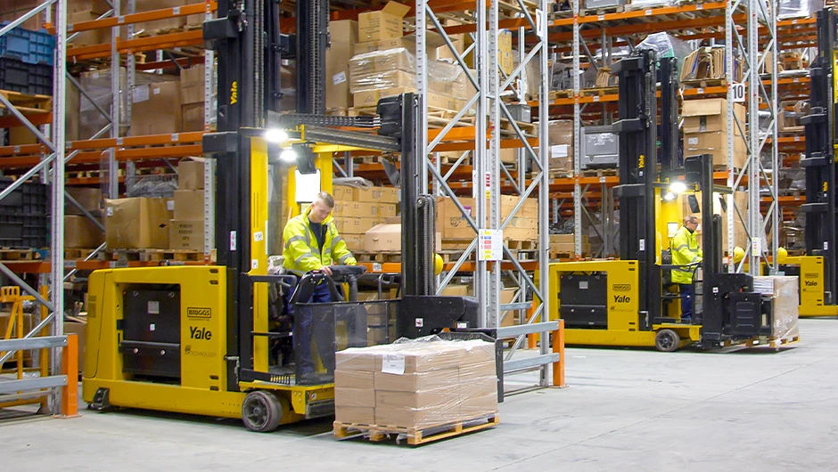 Yale turret truck working in narrow warehouse aisle.