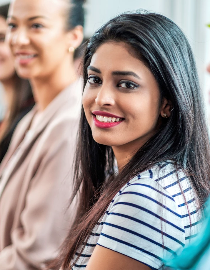Women smiling in office setting. 