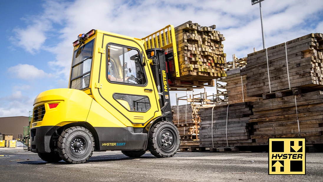 Hyster XT truck transporting load of lumber. 