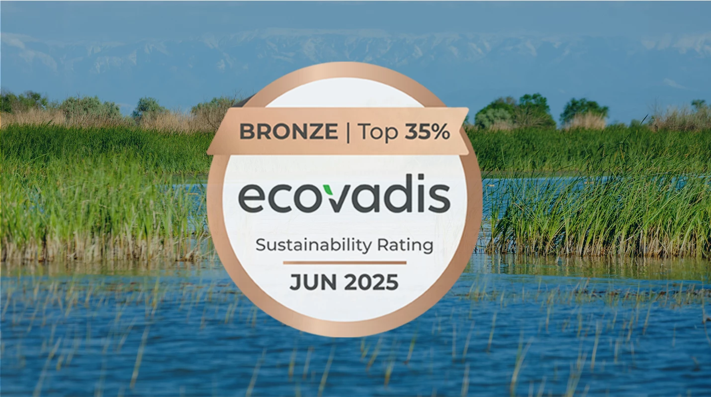 EcoVadis Sustainability Award logo over waterway with grassy vegetation.