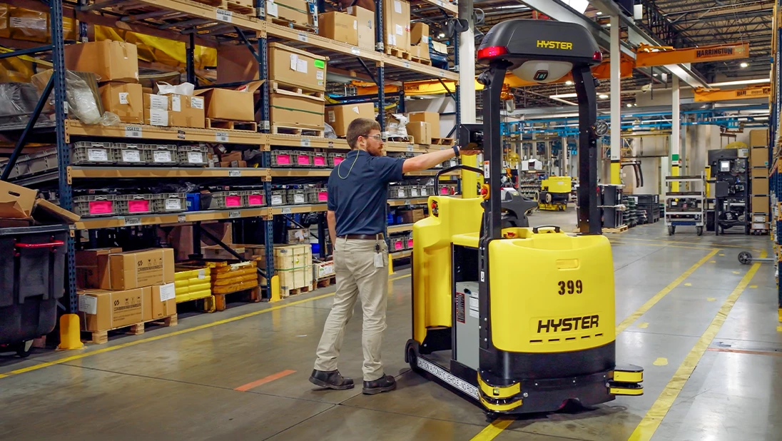 Person pushing touchscreen on Hyster Atlas automated lift truck. 