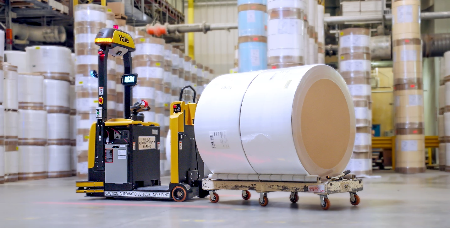 Yale Relay automated lift truck pulling load in warehouse.