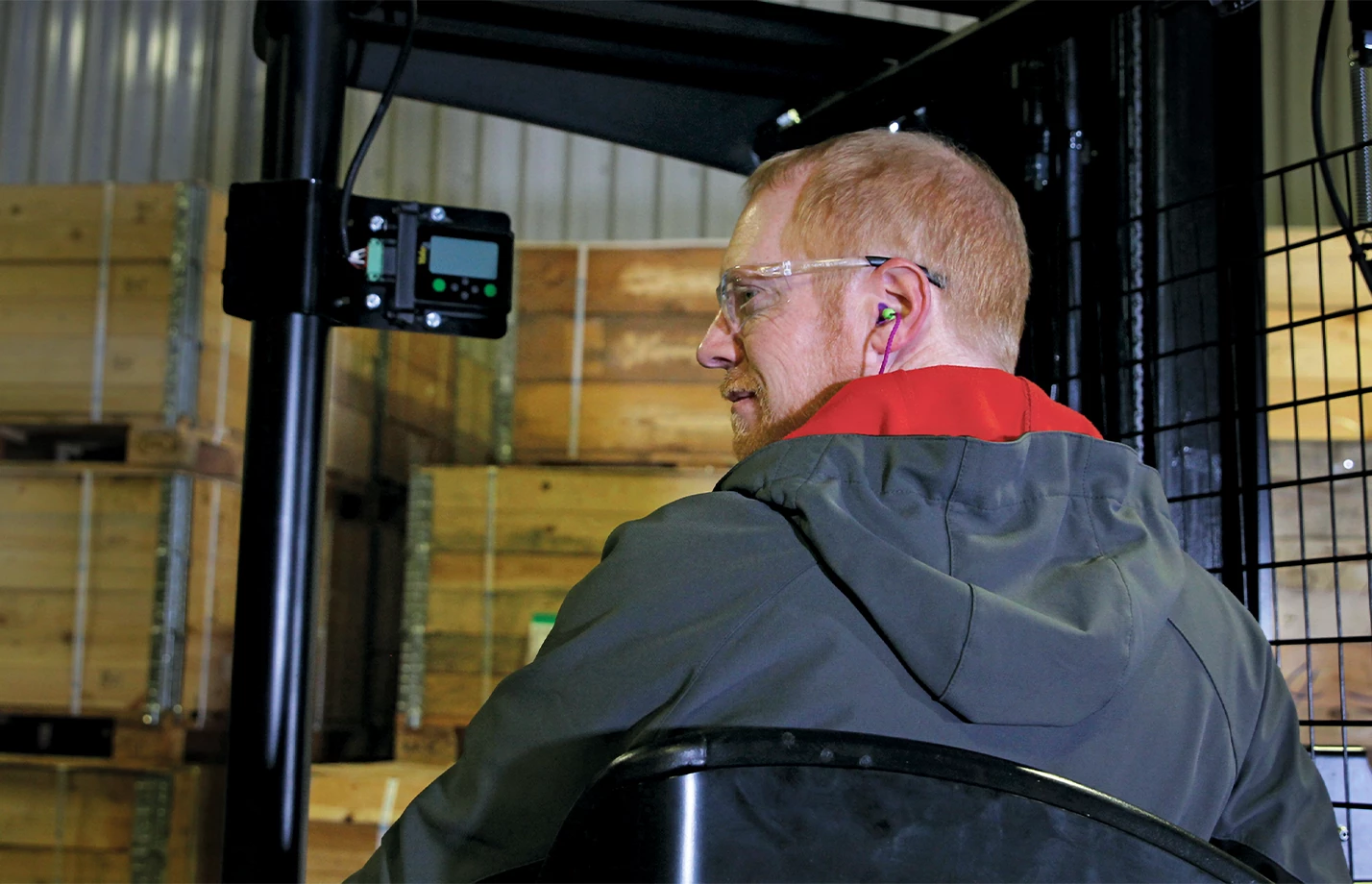 Close-up of an operator driving a Yale forklift in a warehouse.