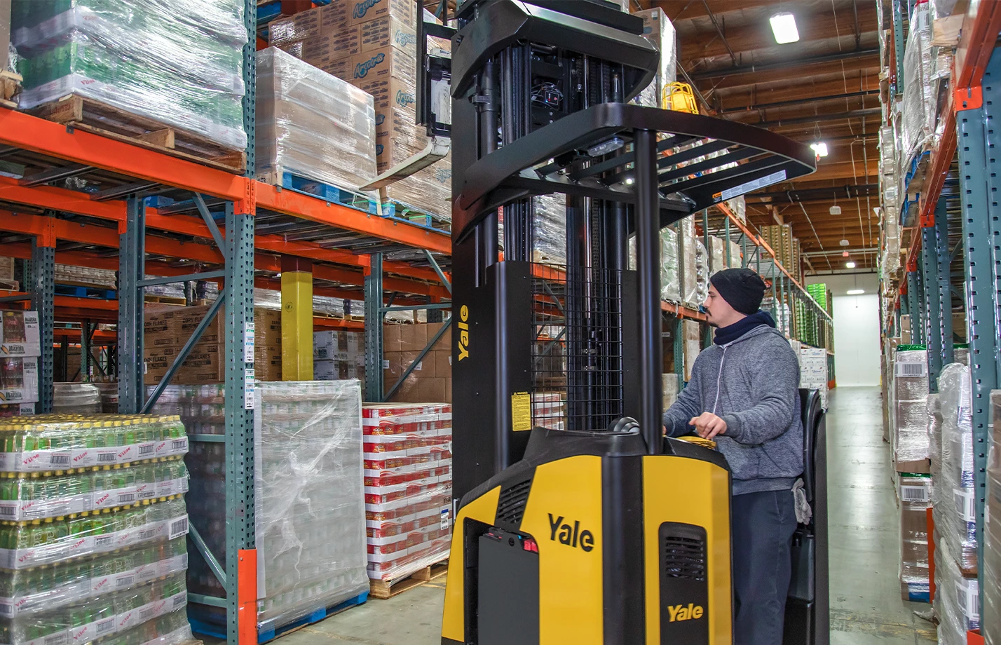 Operator comfortably operating Yale reach truck in warehouse. 